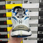 Back view of white and blue sneakers with Balenciaga heel logo and gray stabilizer