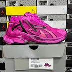 Pink lace-up sneaker with black accents and chunky sole, shown on a retail box