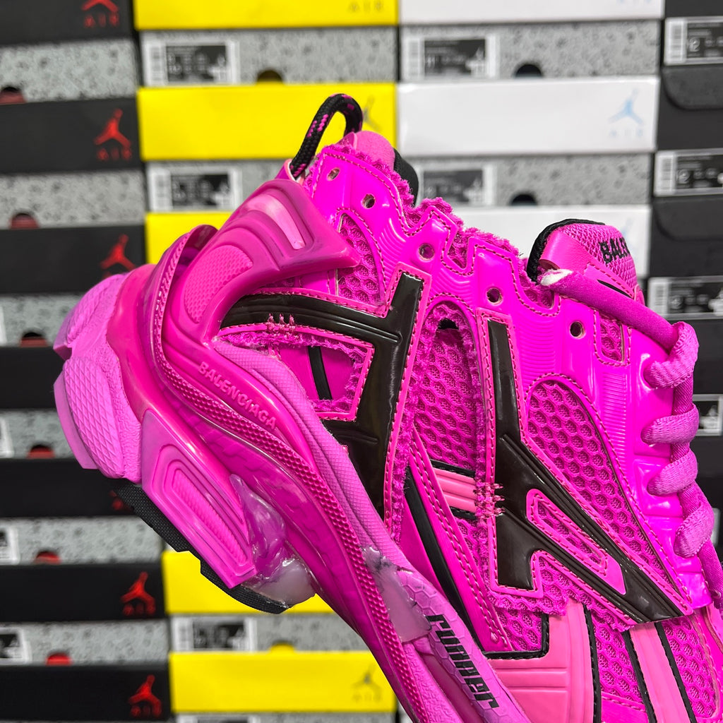 Pink Balenciaga sneaker with black logo accents, lace-up front, and cushioned sole