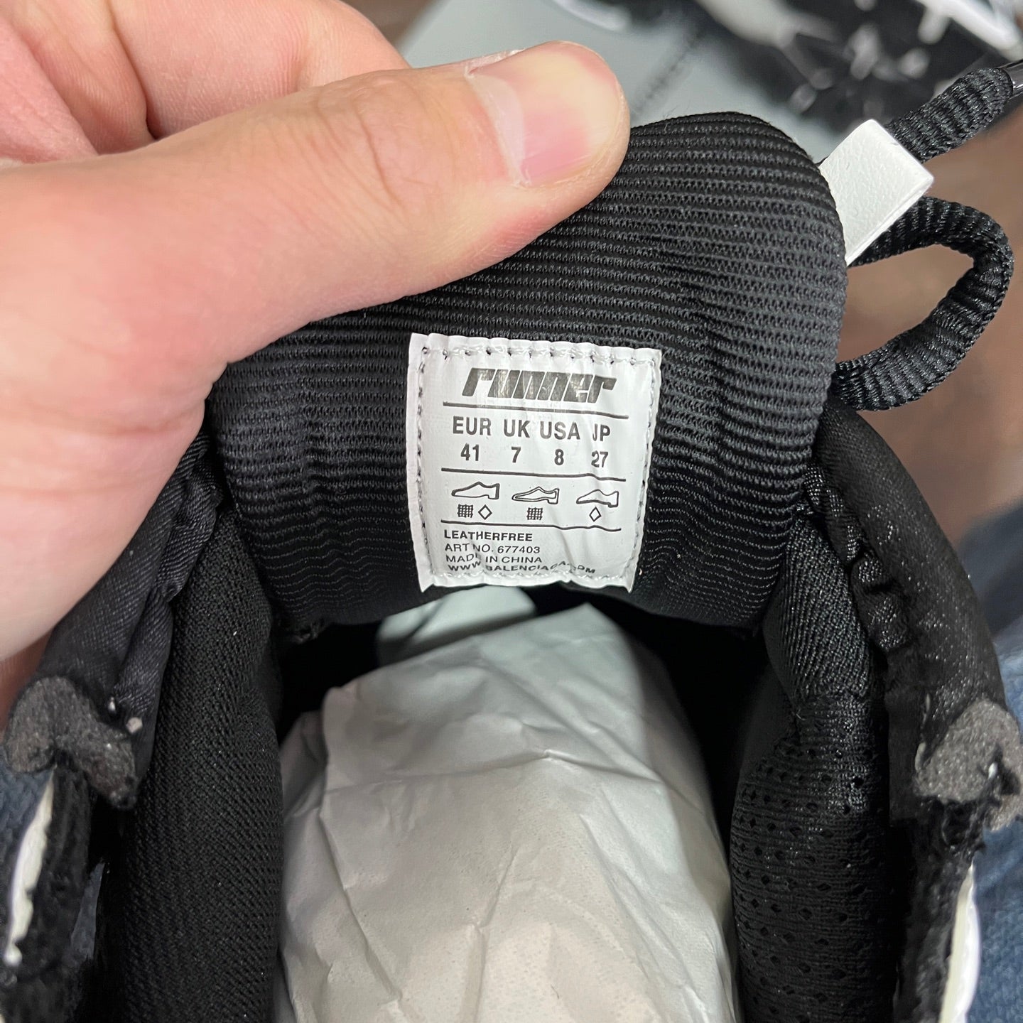 Black sneaker interior size label on fabric tag with measurement markings