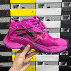Pink lace-up athletic sneaker with black side stripes, perforations, and thick sole