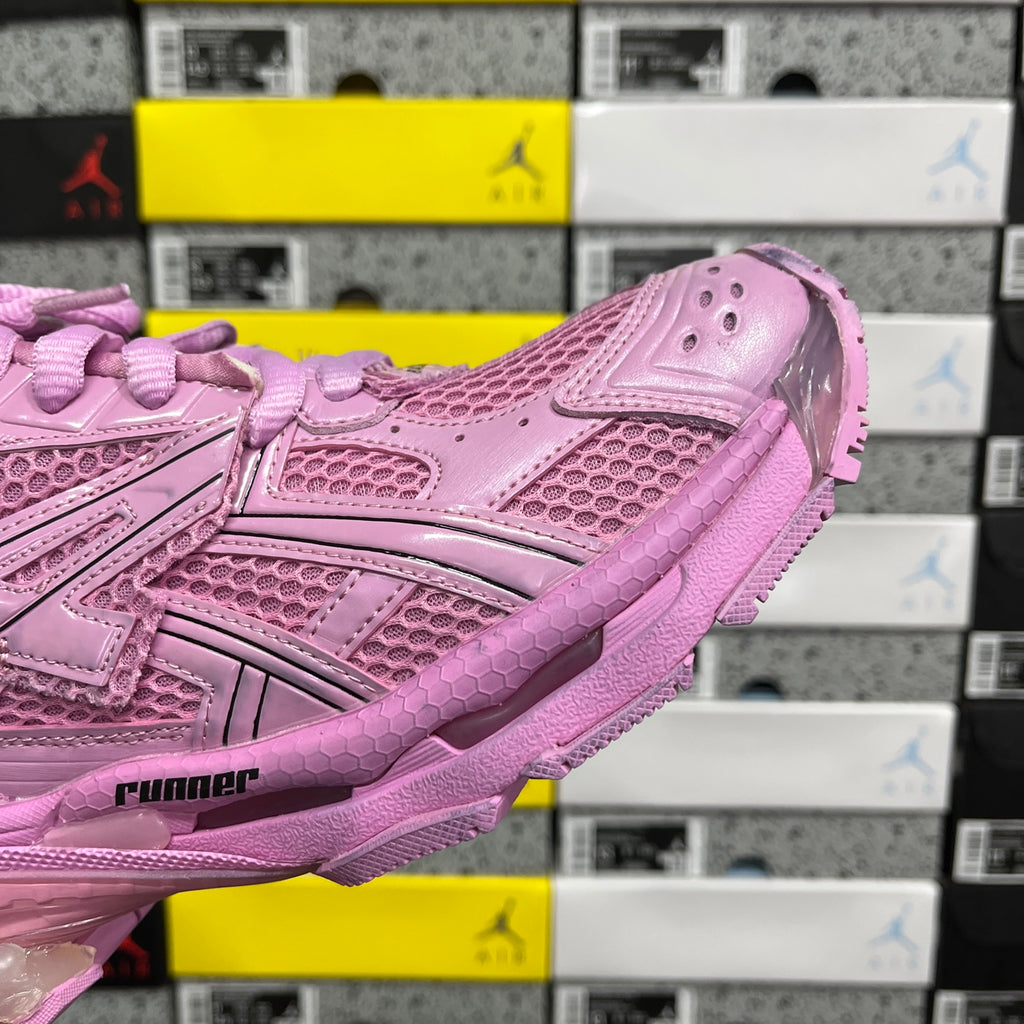 Pink sneaker side panel with perforated mesh texture and strap detail.