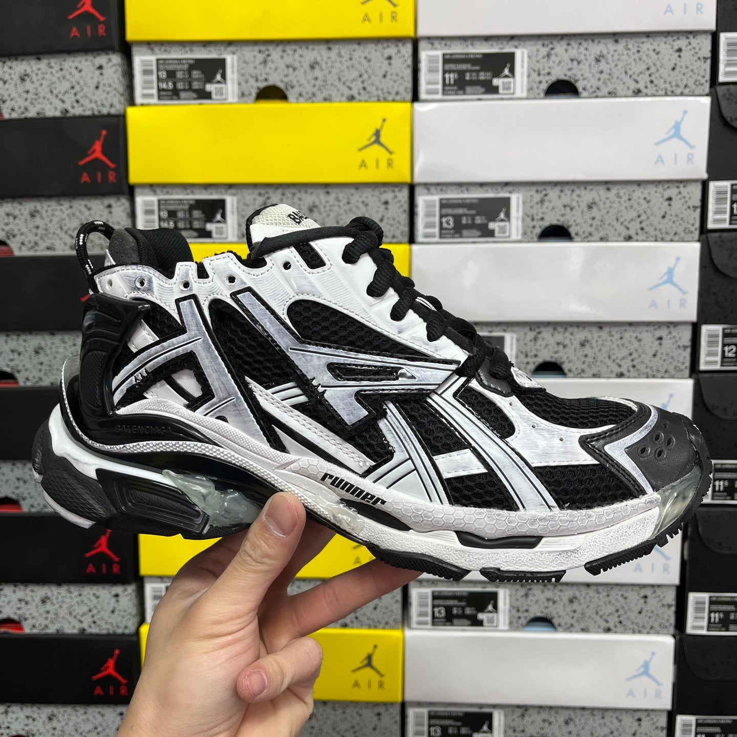 Black and white athletic sneakers with black laces and chunky runner sole