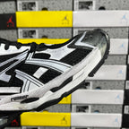 Black and white sneaker side profile with bold stripe accents and chunky sole