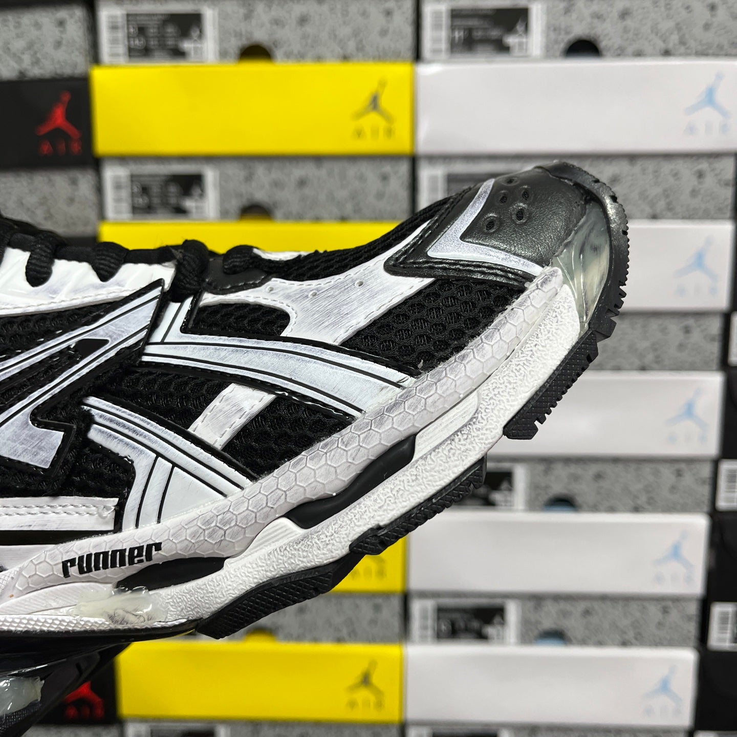 Black and white sneaker side profile with bold stripe accents and chunky sole