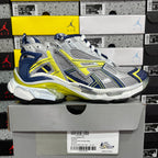 Unisex runner shoes on box, silver mesh with blue panels and yellow-green trims
