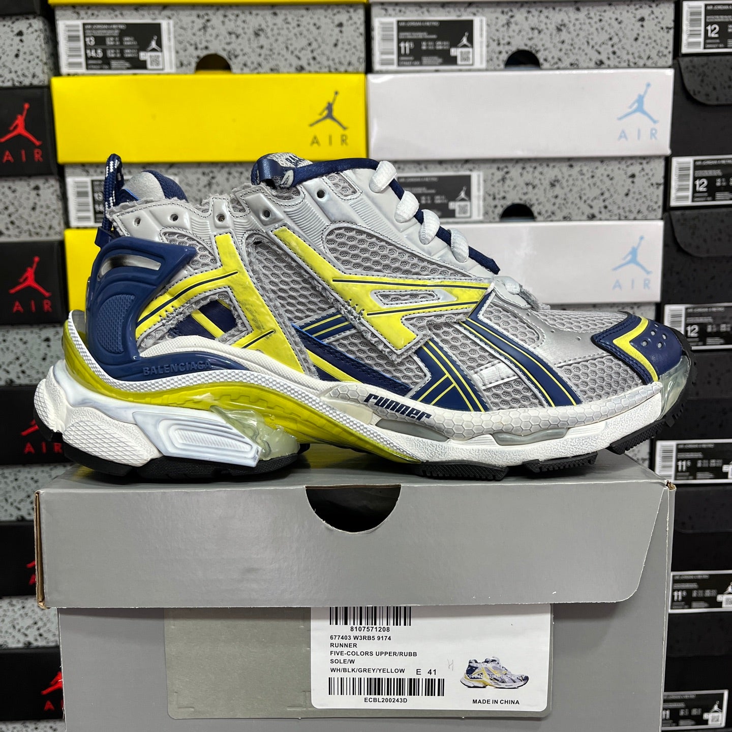 Unisex runner shoes on box, silver mesh with blue panels and yellow-green trims