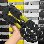 Unisex runner shoe outsole, black tread with yellow-green and silver details