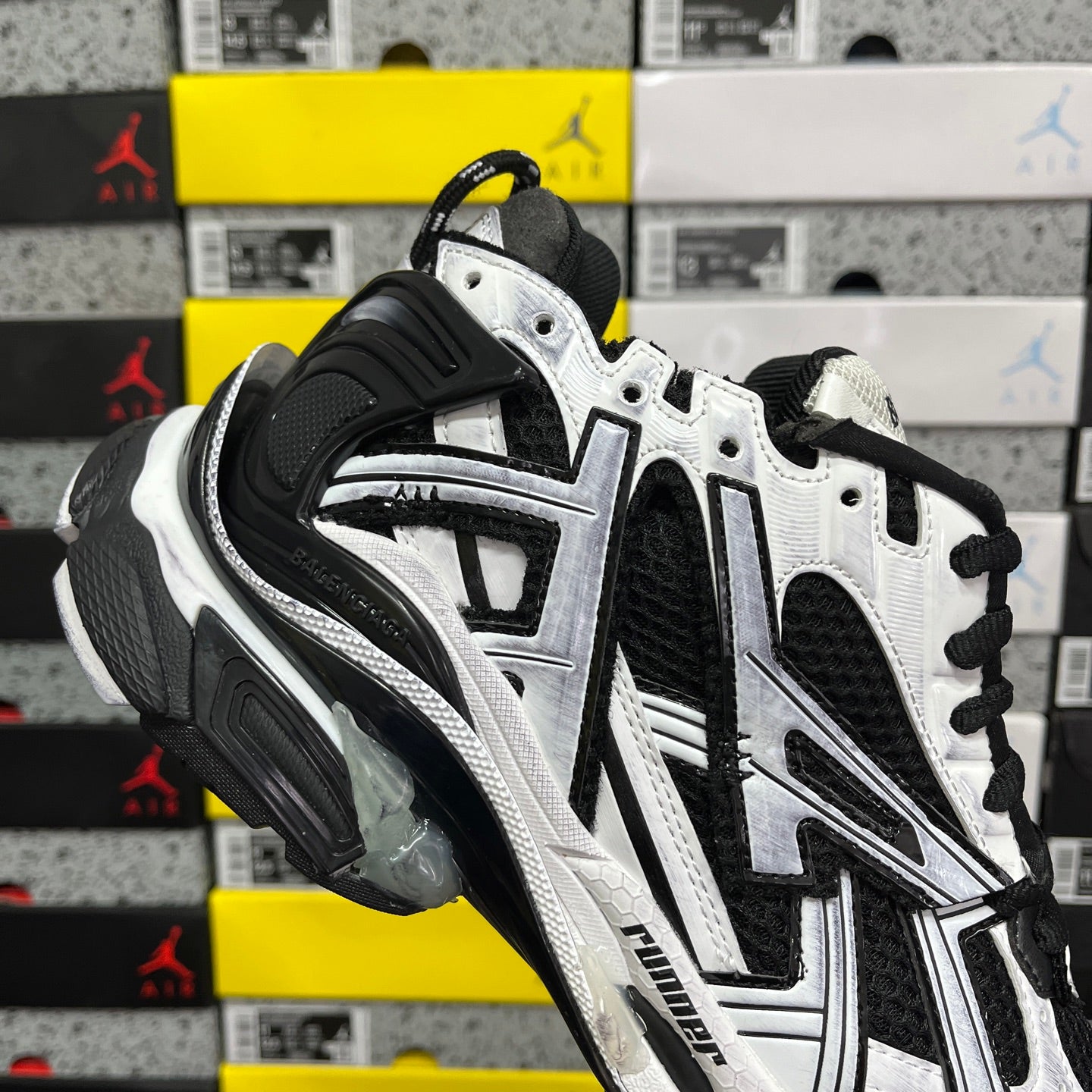 White and black sneakers with perforated details and black lace-up front
