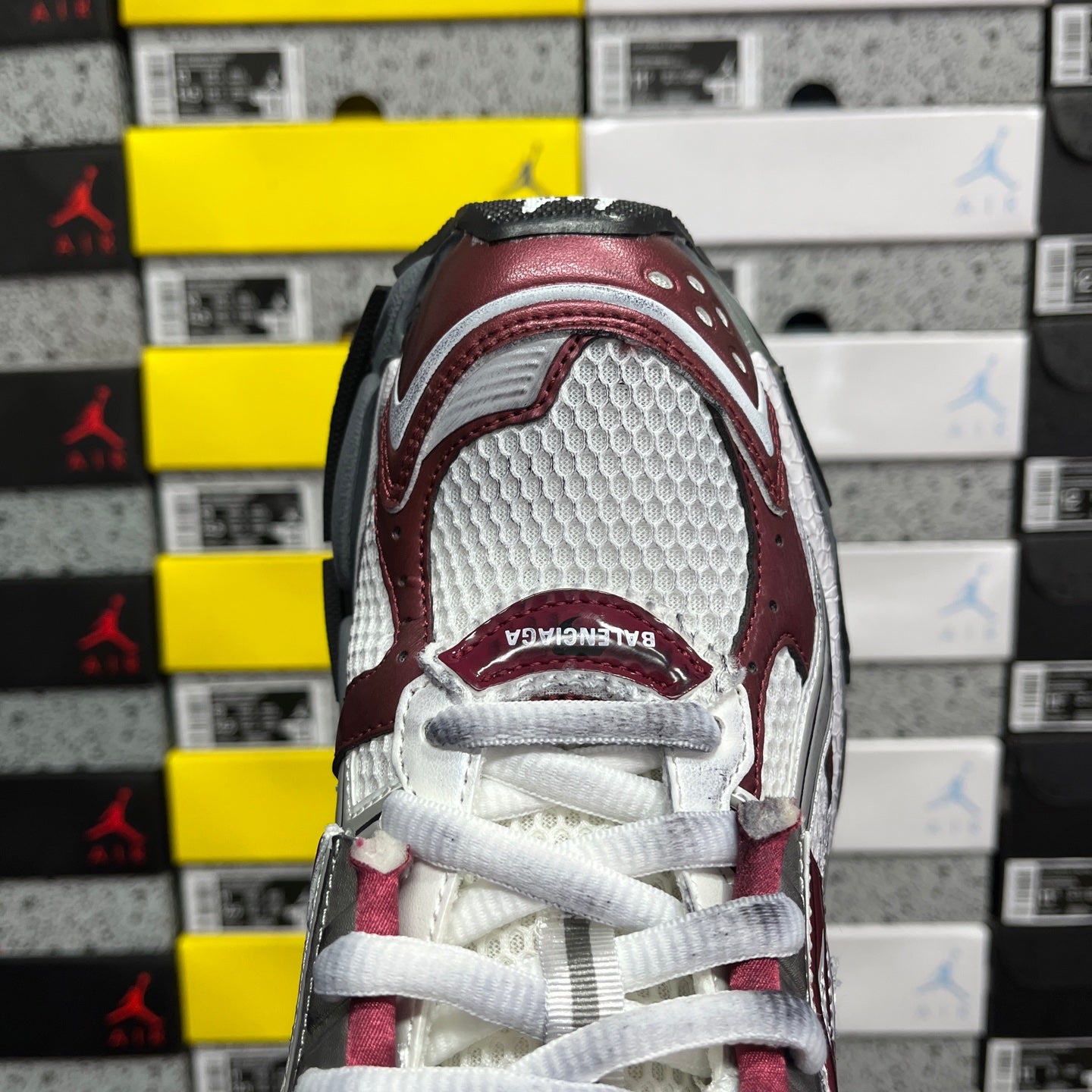 Balenciaga sneakers heel close-up with burgundy collar, white laces, rear logo patch