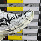 White Balenciaga sneakers with black writing across side and chunky outsole tread