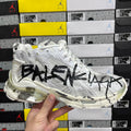 White Balenciaga sneakers with black graffiti-style logo on textured side