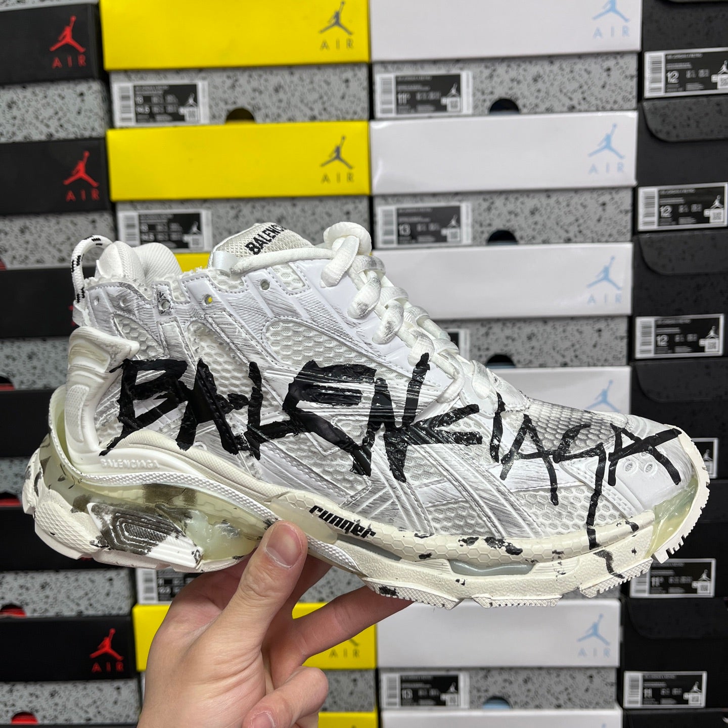 White Balenciaga sneakers with black graffiti-style logo on textured side