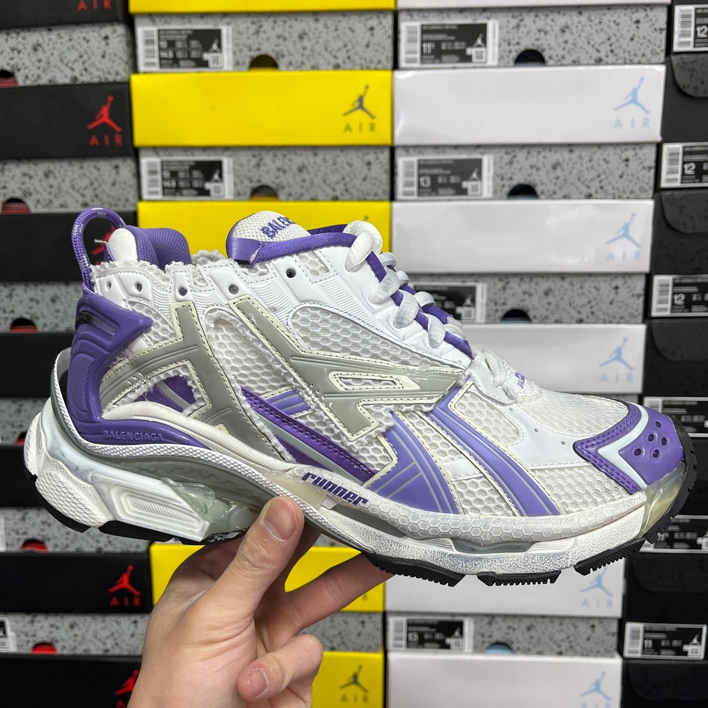 White and purple lace-up sneaker with textured panels and logo trim.