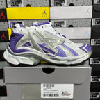 White and purple lace-up sneaker with chunky sole and side branding detail.