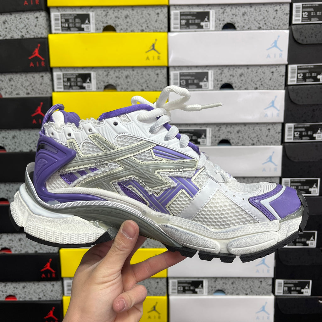 White and purple lace-up sneaker with purple accents and chunky athletic sole.