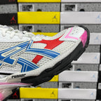 Unisex sneaker side profile with white mesh, blue overlays, red panel, pink accent