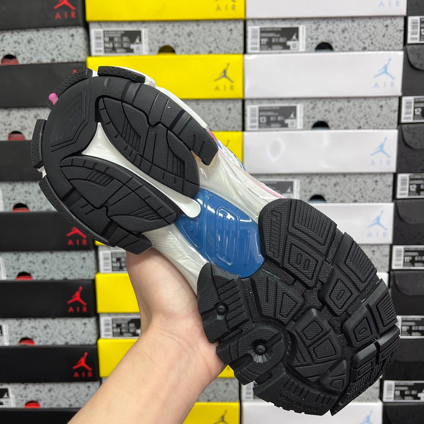 Unisex sneaker outsole with black rubber tread pattern and blue midsole edge