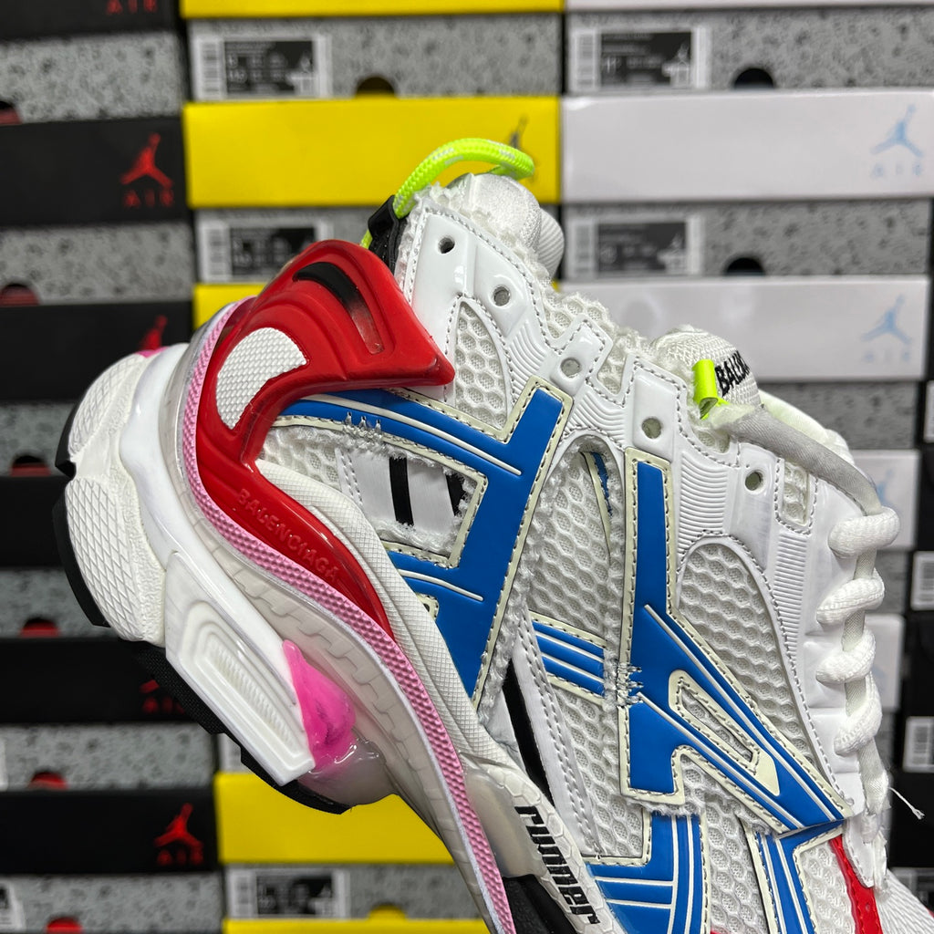 Unisex sneaker side view with red heel strap, blue details, white upper, neon green laces