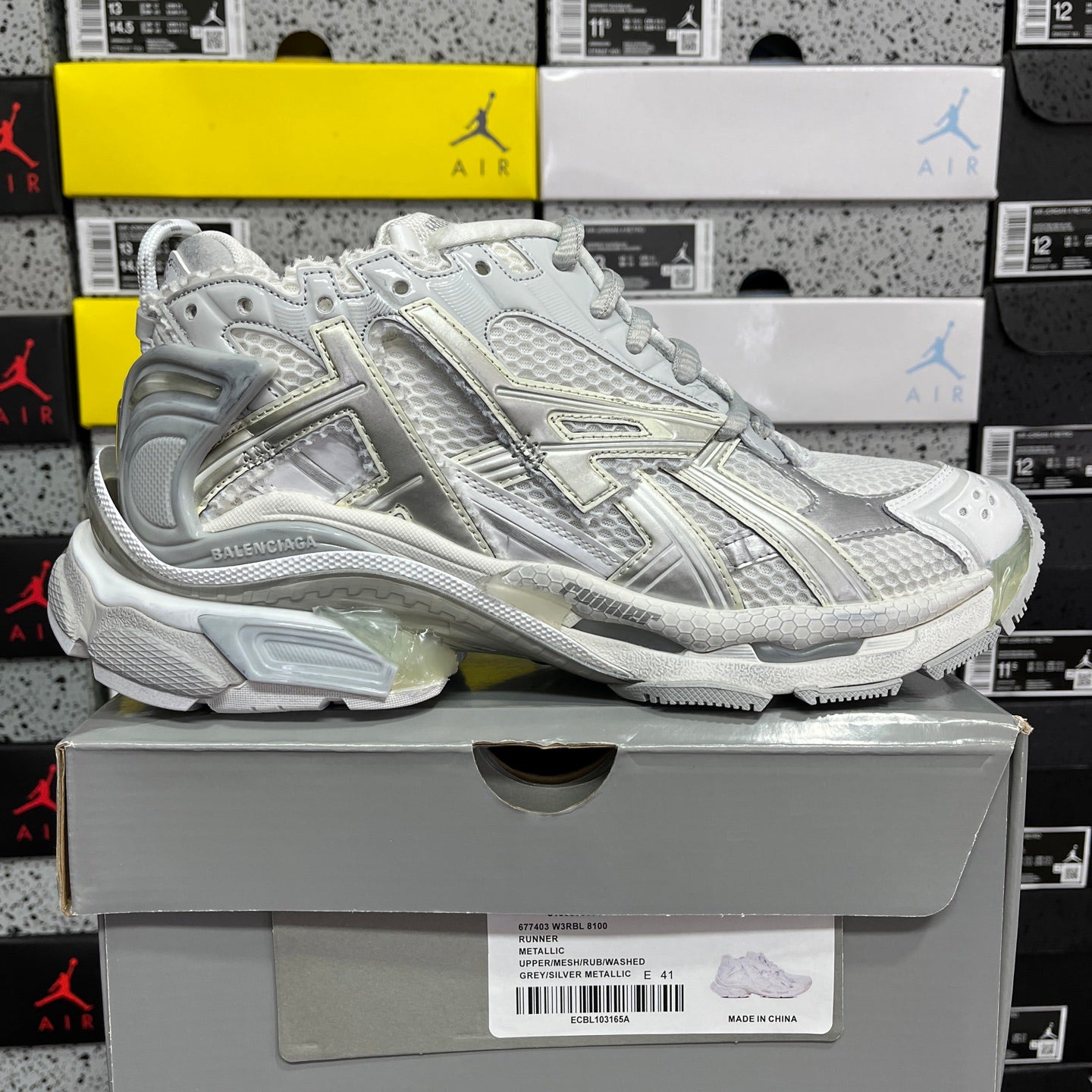 Light silver/white lace-up sneaker with reflective trim and thick sole