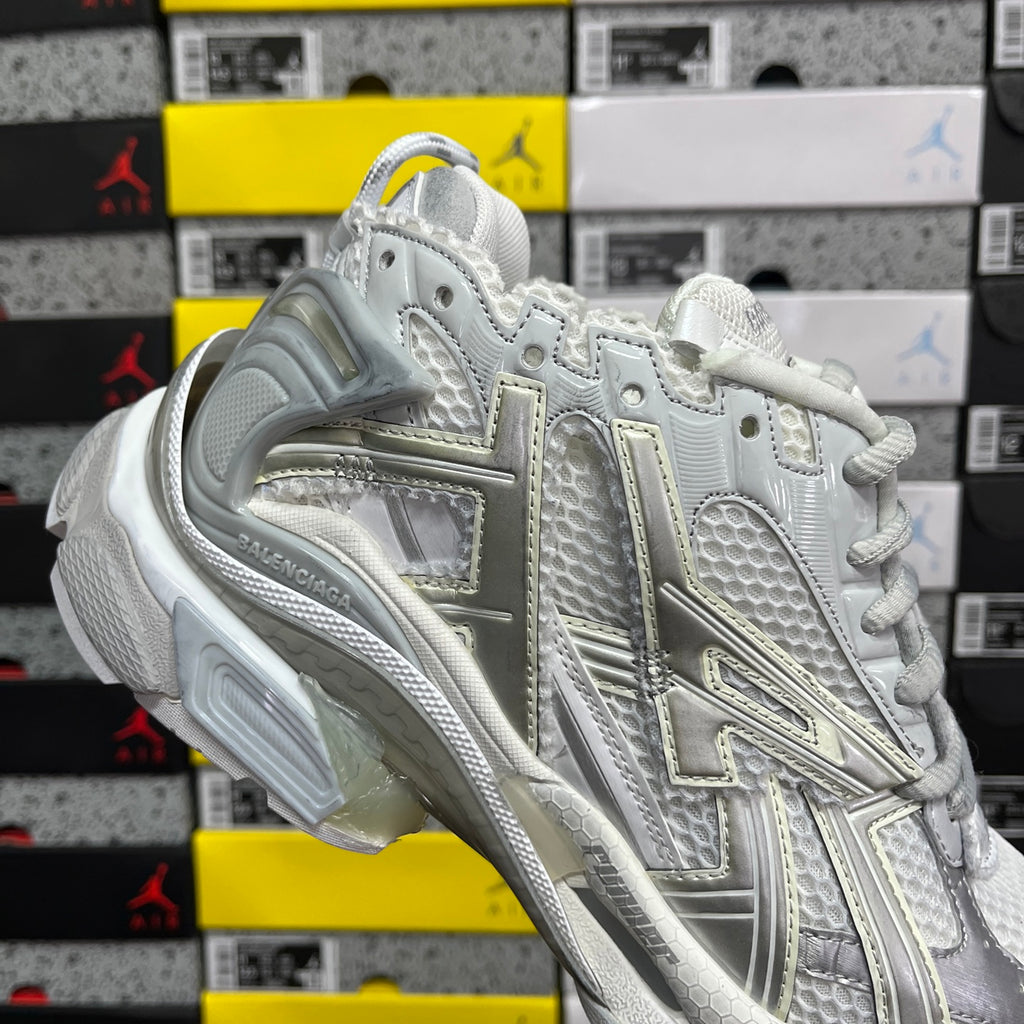 Light silver/white sneaker with metallic logo panel and air-cushioned sole