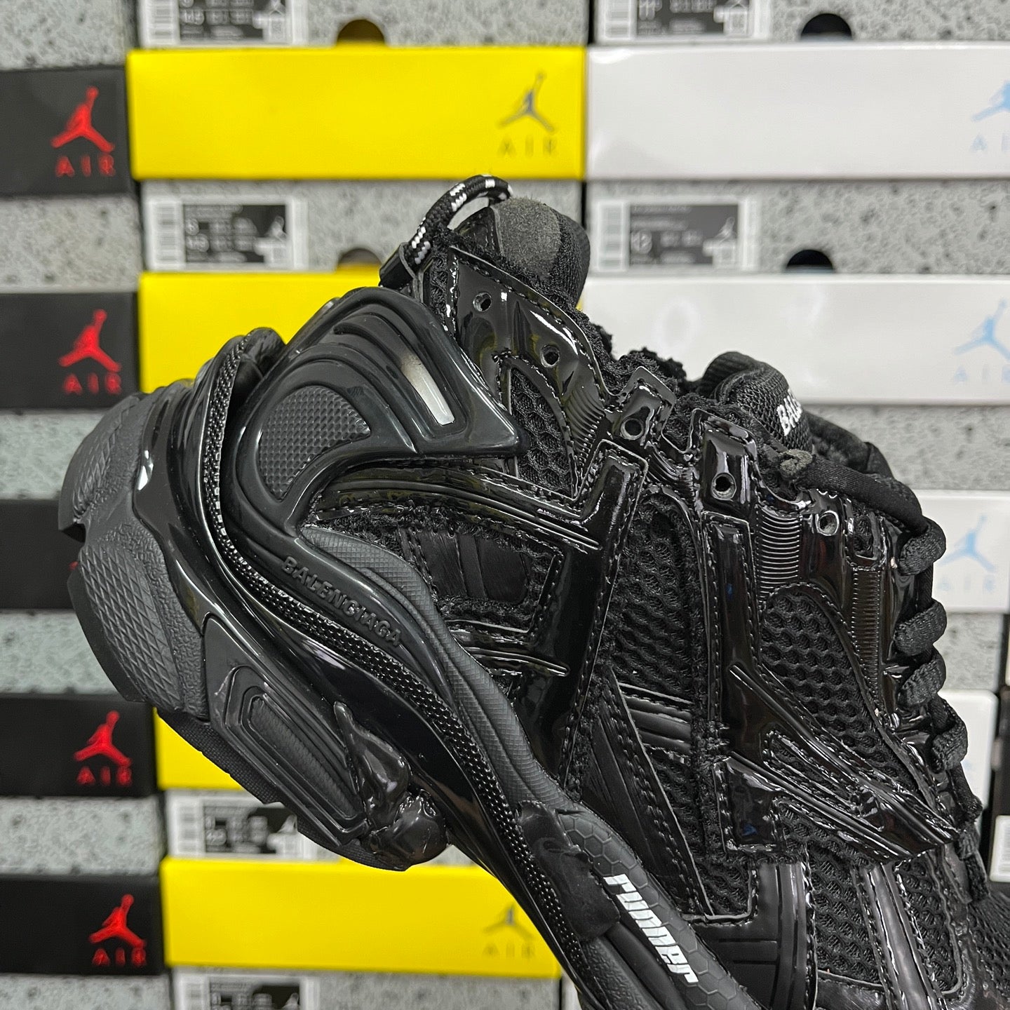 Black Balenciaga running sneaker, angled side view with metallic-looking stripe details
