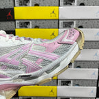 White and pink sneaker side view with striped overlays and thick sole