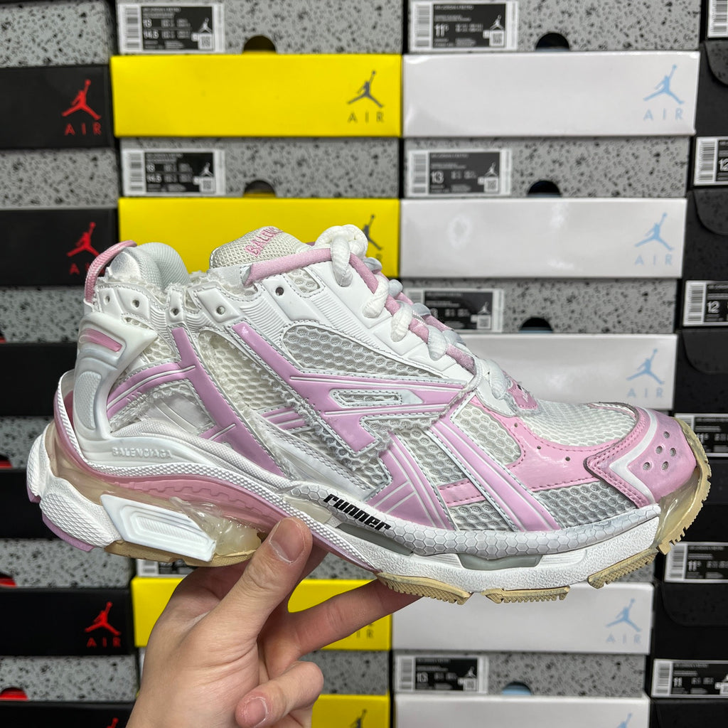 White and pink running sneaker with textured panels, lace-up, and cushioned sole