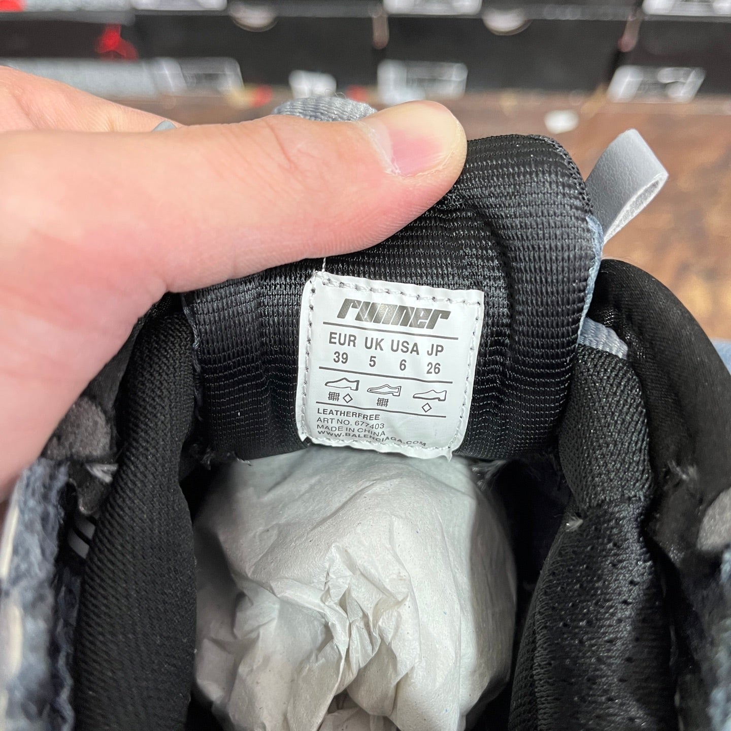Inside label on black-and-grey lace-up sneaker, size chart and sizing numbers.