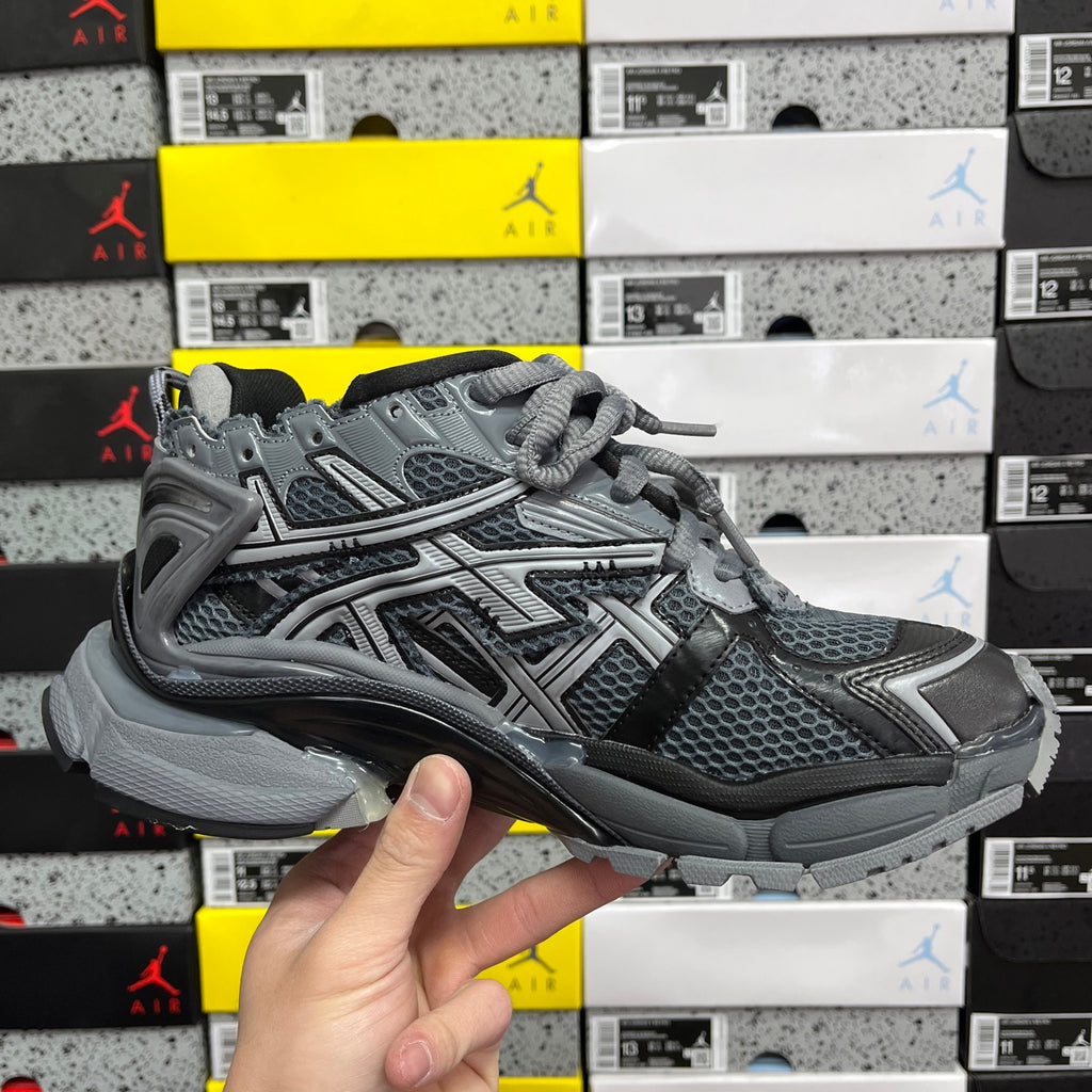 Grey and black lace-up runner sneaker with mesh upper and chunky protective sole.
