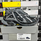 Grey lace-up runner sneaker with mesh upper, padded collar, and sporty stripes.