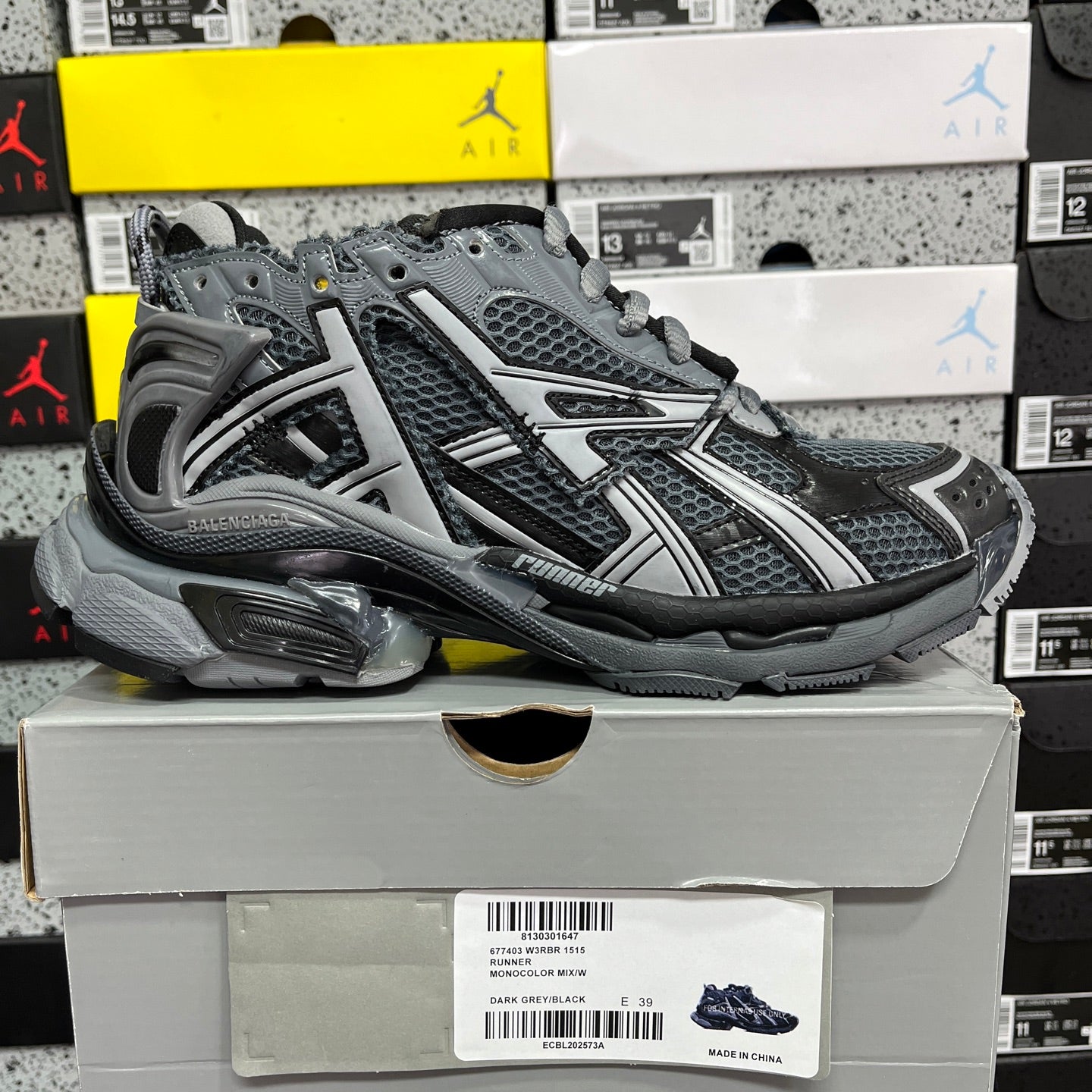 Grey lace-up runner sneaker with mesh upper, padded collar, and sporty stripes.
