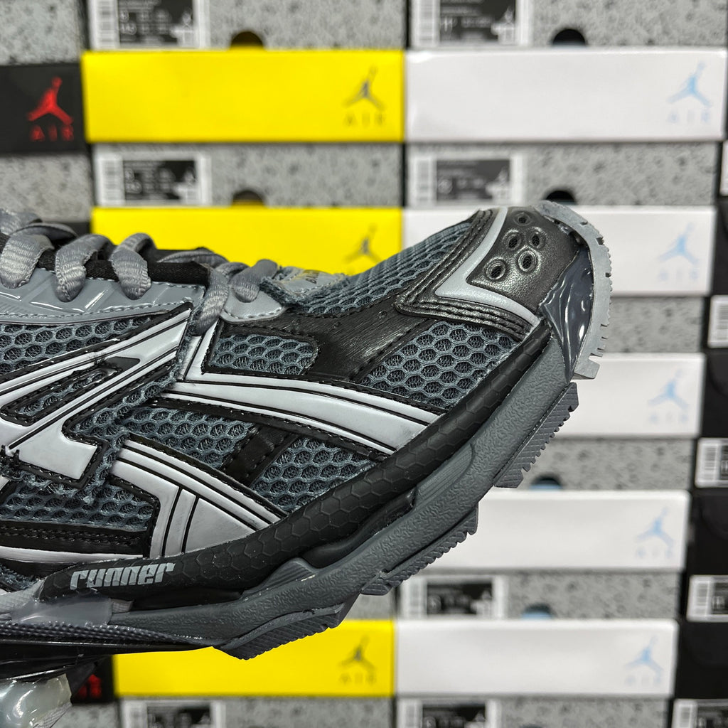 Grey mesh and synthetic runner sneaker side view with lace-up and strap detail.