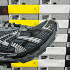 Grey mesh and synthetic runner sneaker side view with lace-up and strap detail.