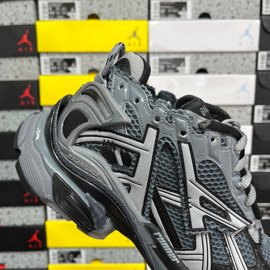 Grey lace-up runner sneaker with sculpted midsole and mesh panels.