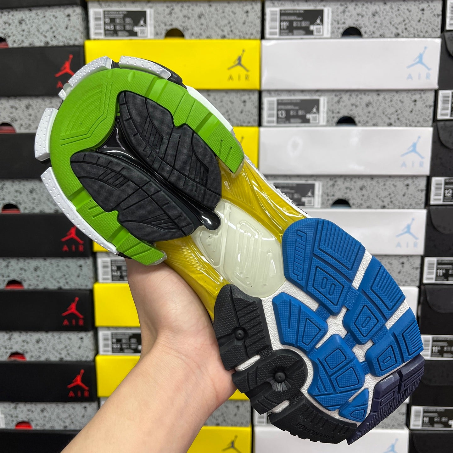 Multicolor sneaker outsole with green, yellow, and blue tread pattern