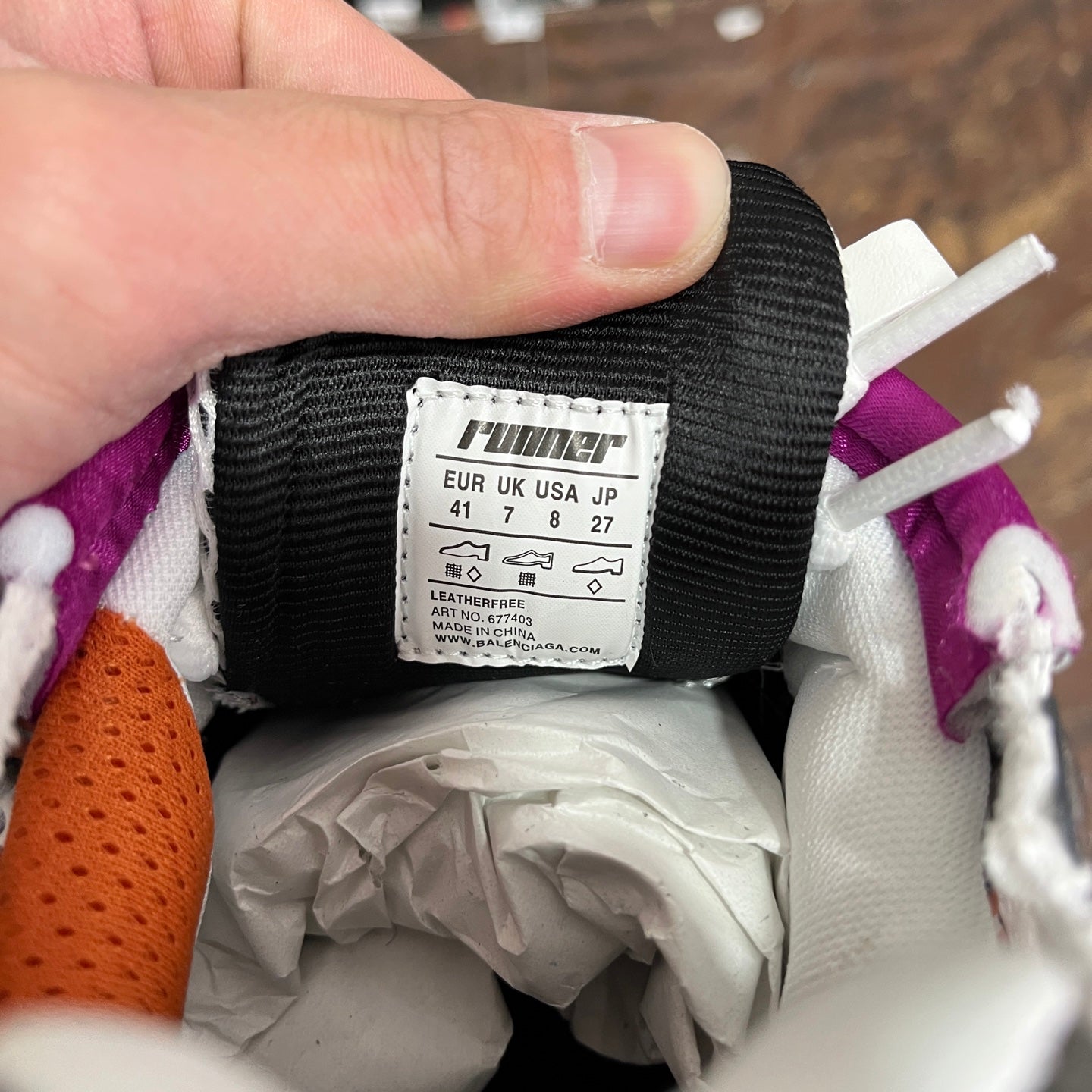 Sneaker inner label showing sizes and leather text, near white sock liner