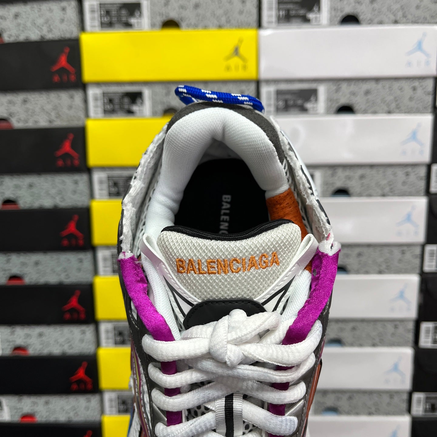 Silver sneaker heel with Balenciaga logo, purple collar lining, and white laces