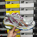 Silver multi-panel sneaker with purple and orange stripe, white laces and blue sole