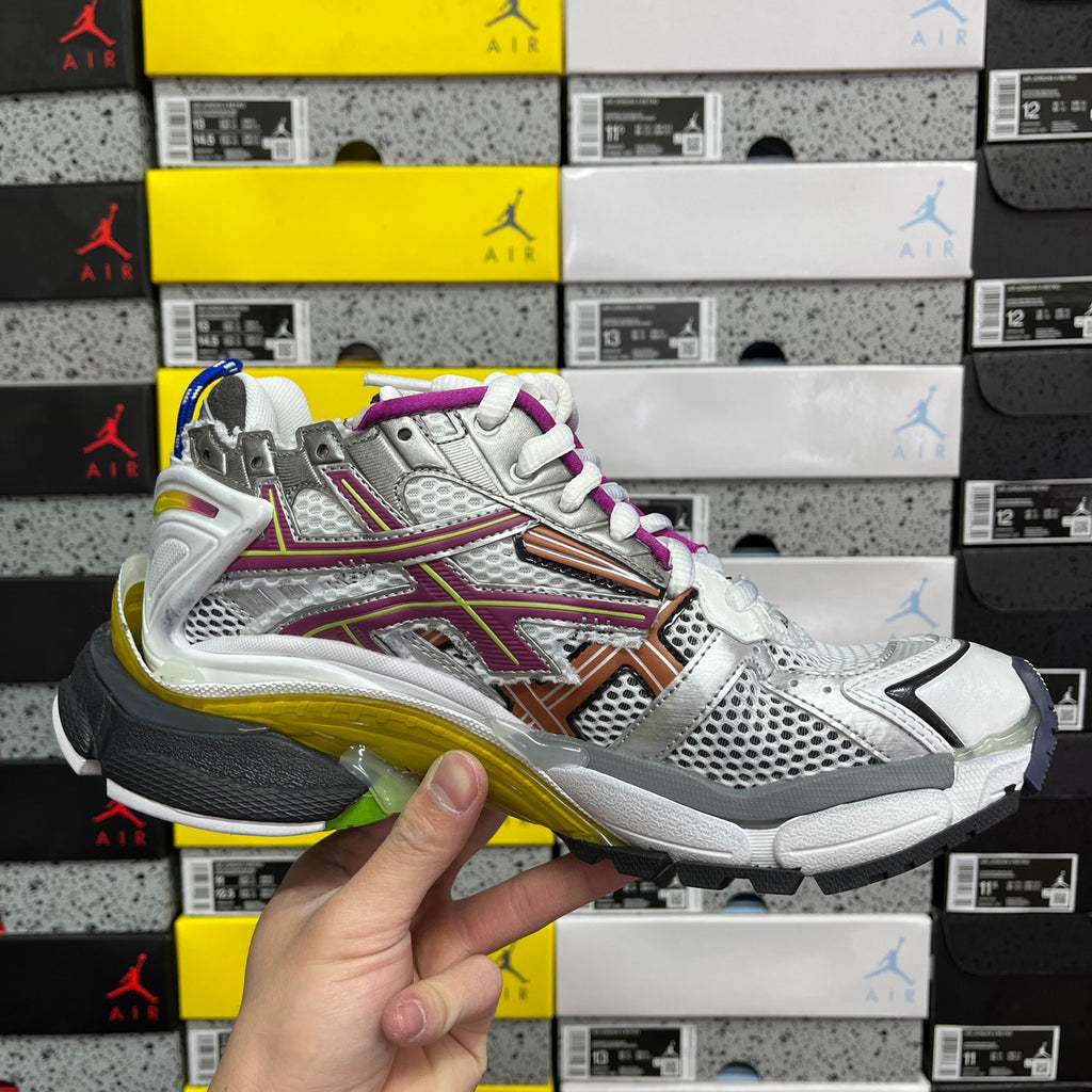Silver multi-panel sneaker with purple laces, orange stripe, and blue outsole trim
