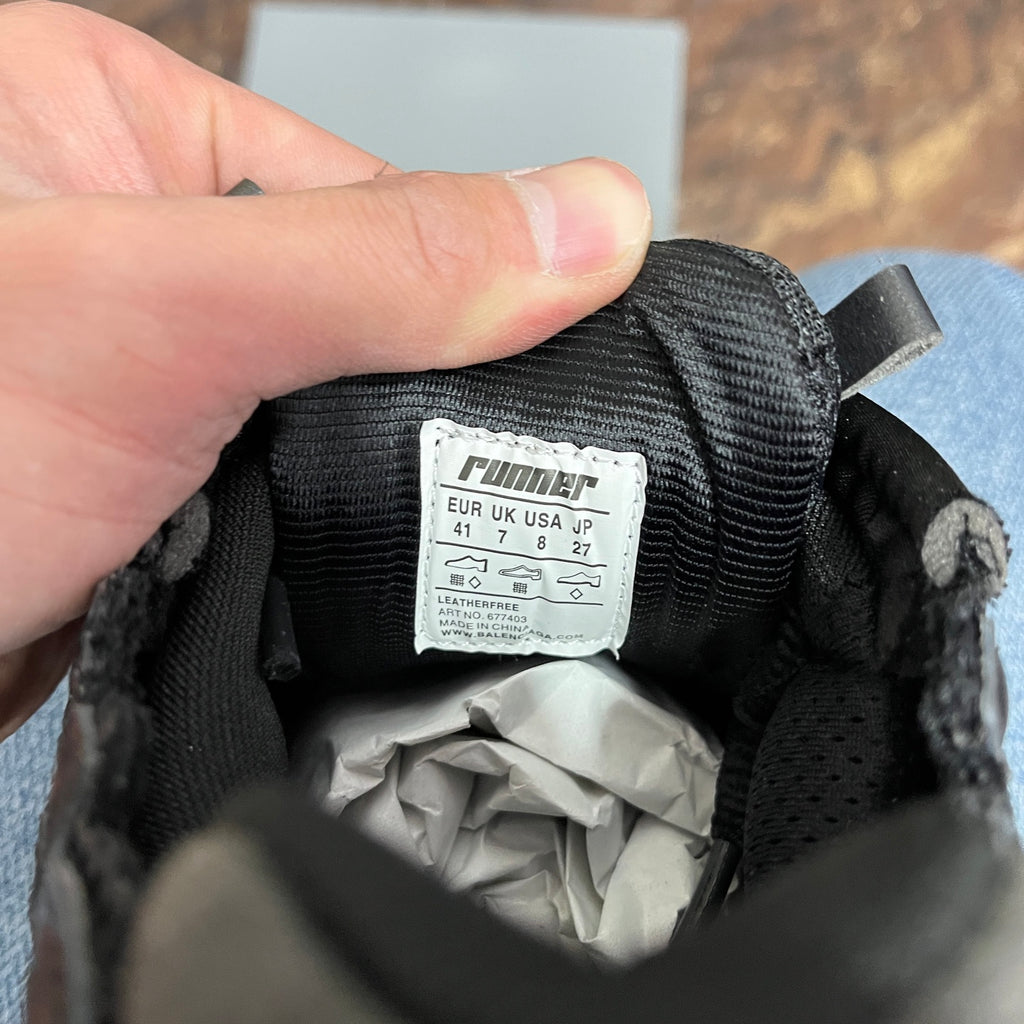 Black runner sneaker tongue label reading 41 and leather/textile details