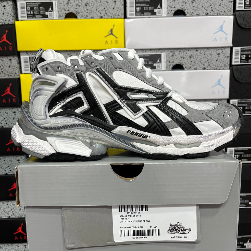 Silver and black high-top sneakers with white laces and thick cushioning sole
