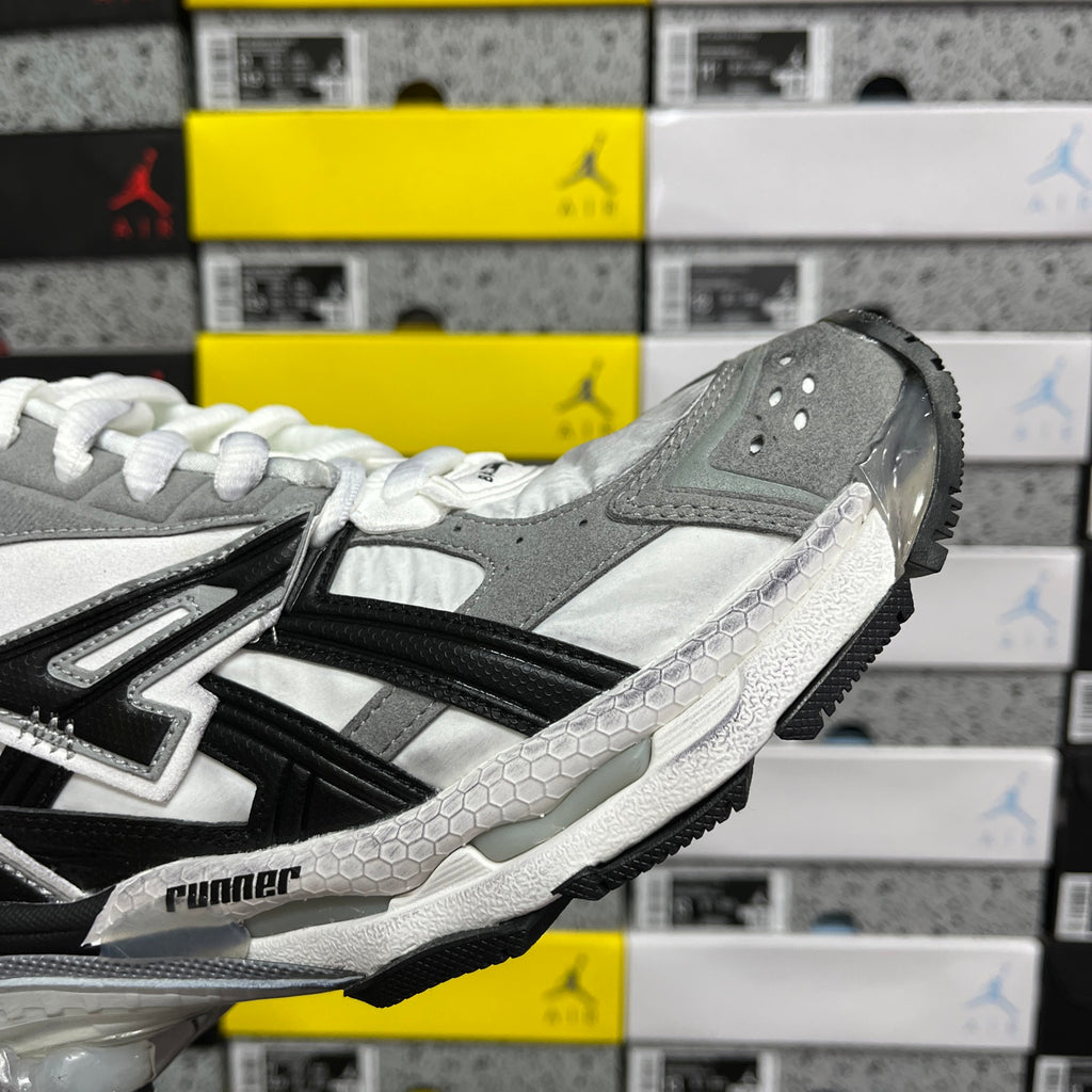 Silver, gray, and black high-top sneakers with white laces and side stripes