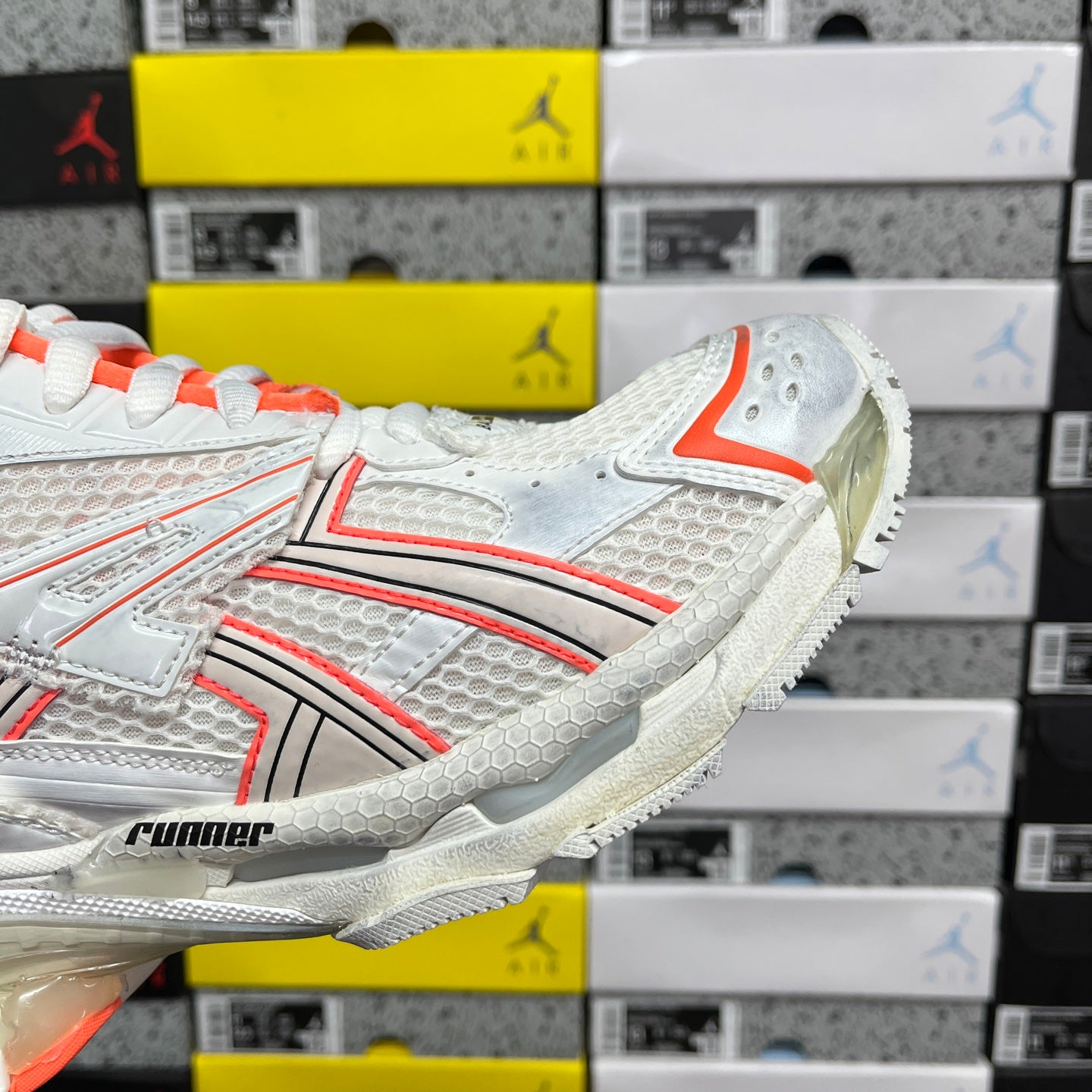Balenciaga runner sneakers side detail, white upper with orange trim and runner logo