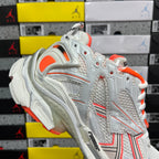 Balenciaga runner sneakers quarter close-up, white mesh with orange lining and laces