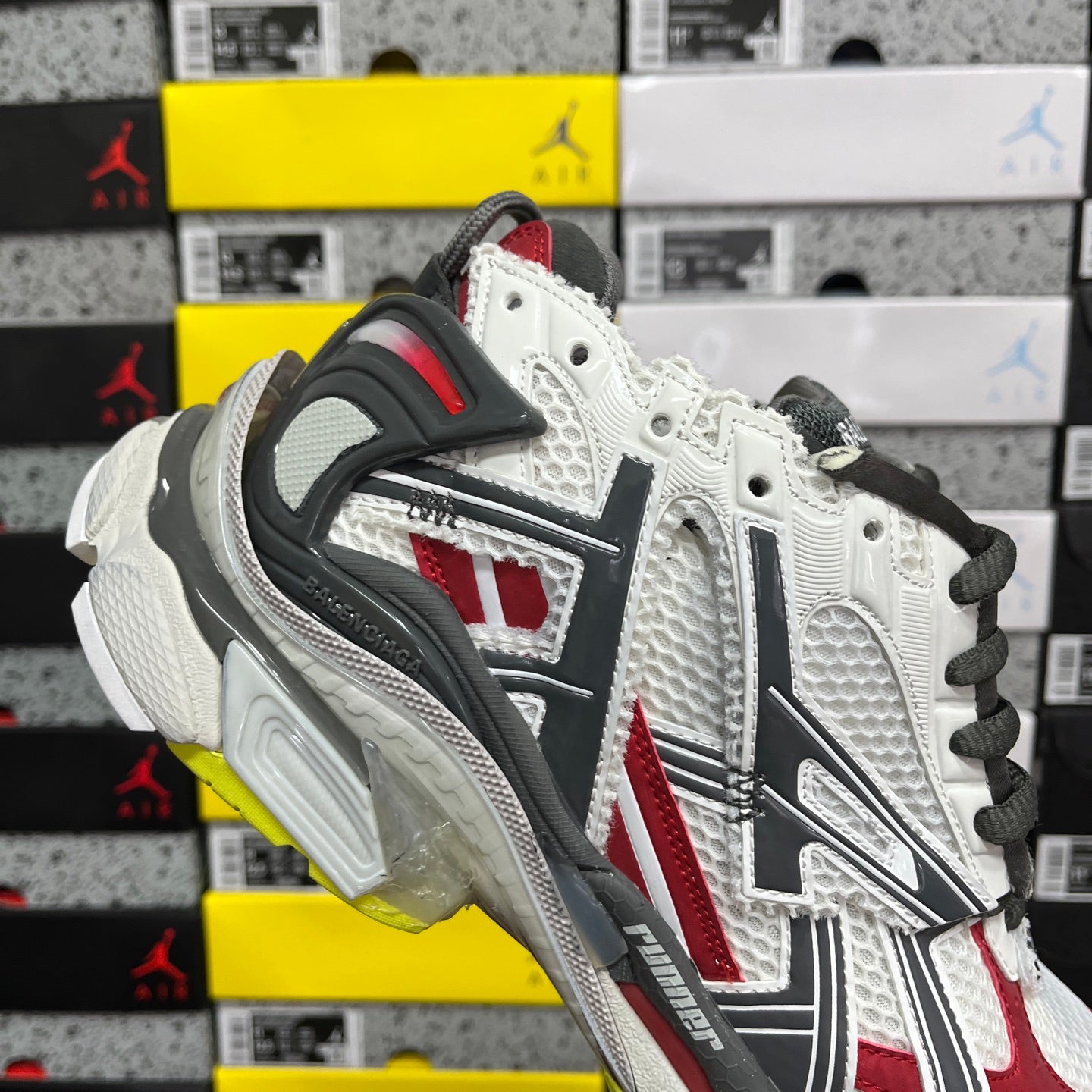 White and red sneaker with black laces and dark heel counter, textured cushioning sole