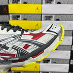 White, red, and black sneaker quarter panel with textured eyelets and yellow trim