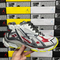 White, red, and black low-top sneaker with black laces and bright yellow sole edge