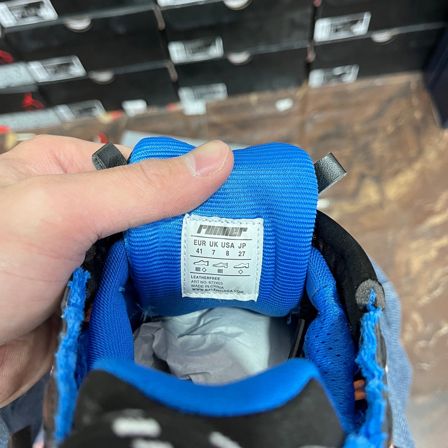 Unisex sneakers inside tongue label on blue fabric, with lace and lining visible