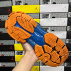 High-top unisex sneakers outsole view: blue tread with orange rubber grips